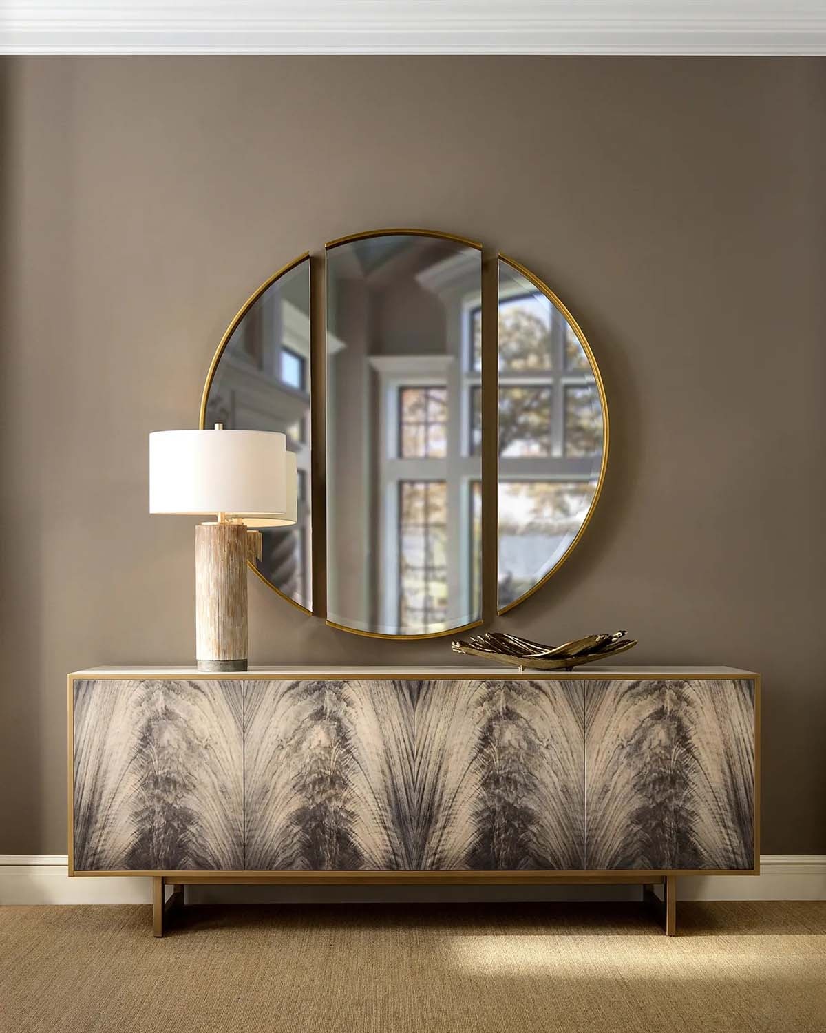  Modern wood patterned credenza veneered in ash and antique beluga finish. The case is set on a steel base in a brushed brass finish, with a  8